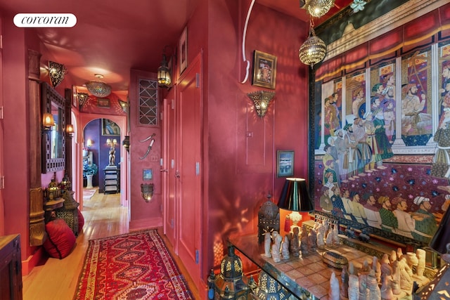 hallway with arched walkways and wood finished floors