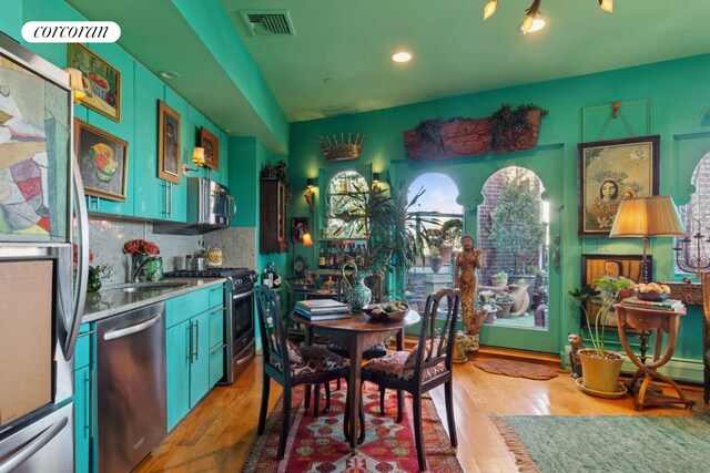 kitchen featuring stainless steel appliances, light wood-type flooring, plenty of natural light, decorative backsplash, and recessed lighting