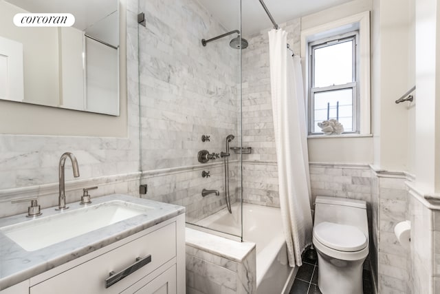 full bath featuring tile walls, vanity, shower / bath combo with shower curtain, toilet, and tile patterned flooring