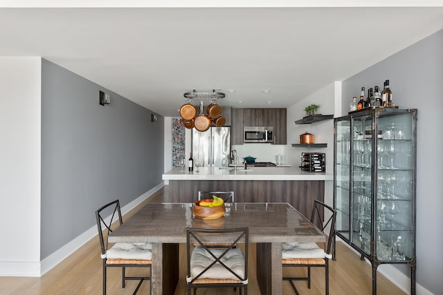 47-28 11th St Unit 6-C, New York City, NY 11101 - dining area featuring light wood-style flooring, baseboards, and a chandelier