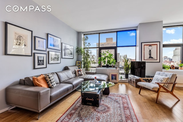 living area with hardwood / wood-style floors, healthy amount of natural light, and floor to ceiling windows