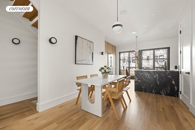 dining room featuring baseboards and light wood-style flooring