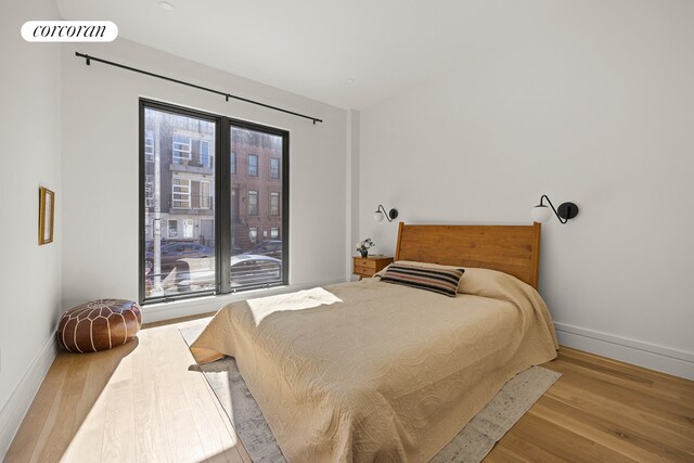bedroom with baseboards and wood finished floors