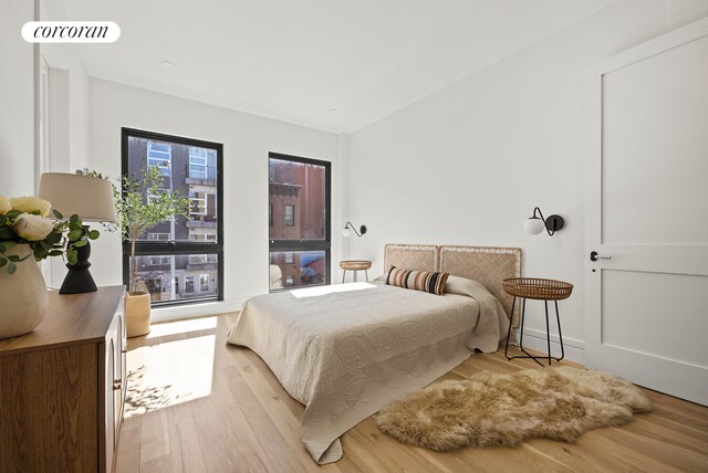 bedroom with light wood-style floors and visible vents