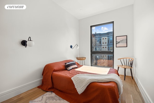 bedroom featuring light wood-style flooring, visible vents, and baseboards