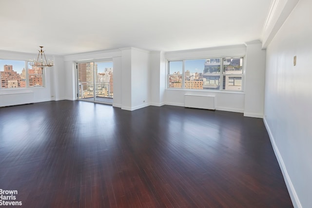 unfurnished living room featuring dark wood-style flooring, a chandelier, and plenty of natural light