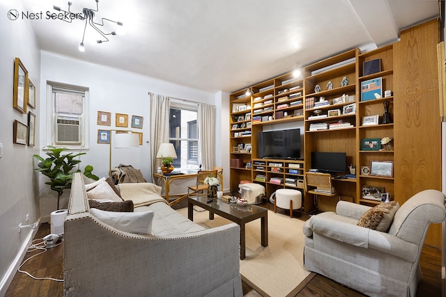living room with an inviting chandelier, built in shelves, baseboards, and wood finished floors