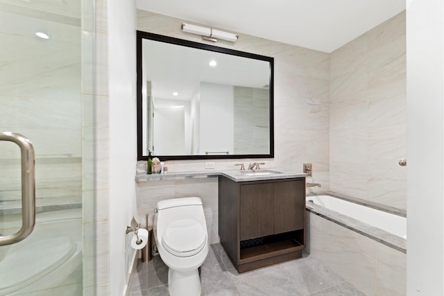 bathroom featuring tile walls, toilet, a tub, a shower with shower door, and vanity