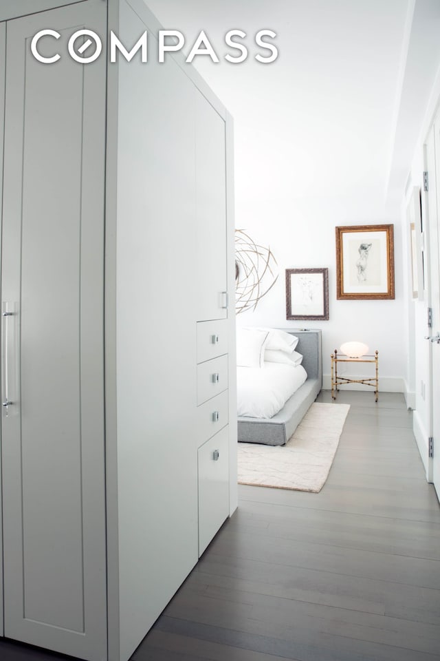 bedroom with wood finished floors and baseboards