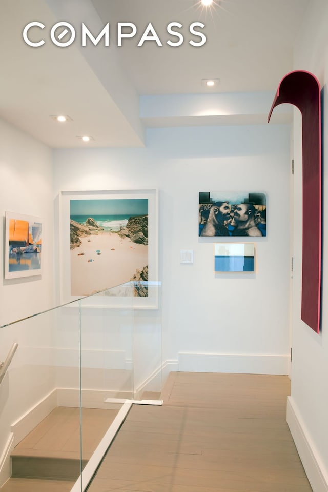 hall with baseboards, light wood-style flooring, and recessed lighting