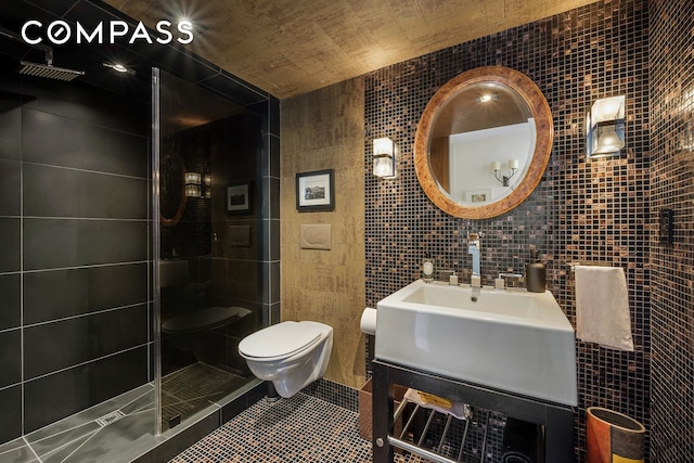 bathroom with tile walls, toilet, a stall shower, vanity, and tile patterned floors