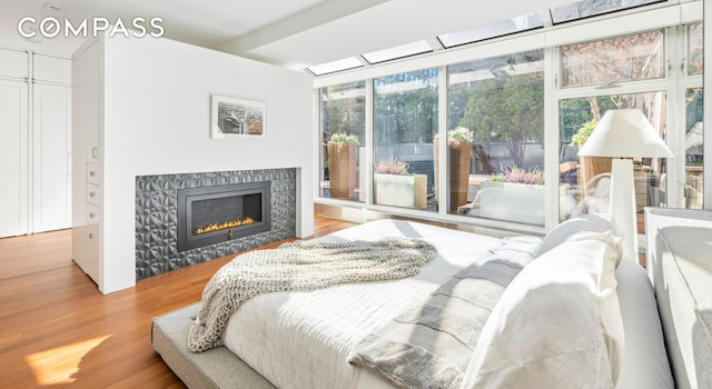 bedroom featuring wood finished floors and a fireplace