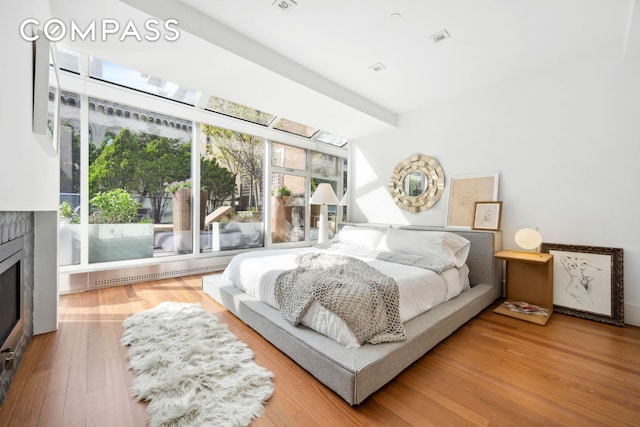 bedroom with a fireplace and wood finished floors
