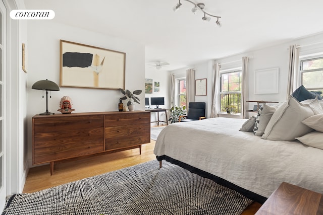 bedroom featuring multiple windows and light wood-style floors
