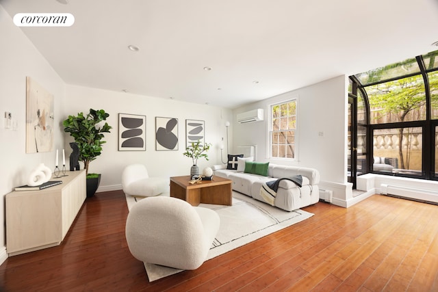 living room with recessed lighting, a wall mounted AC, visible vents, baseboards, and wood finished floors