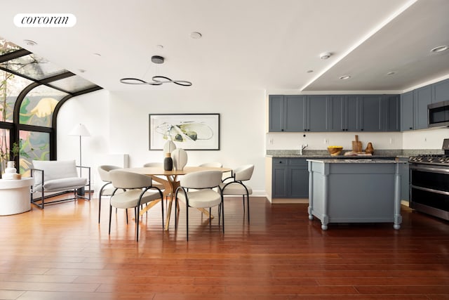 kitchen with a sink, dark wood-type flooring, stone counters, visible vents, and appliances with stainless steel finishes