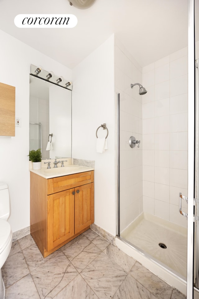 bathroom with baseboards, a shower stall, toilet, and vanity