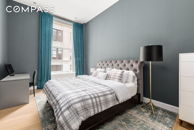 655 6th Ave Unit 5H, New York City, NY 10010 - bedroom with wood finished floors, baseboards, and lofted ceiling