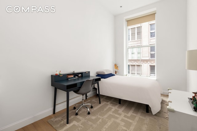 bedroom featuring wood finished floors and baseboards