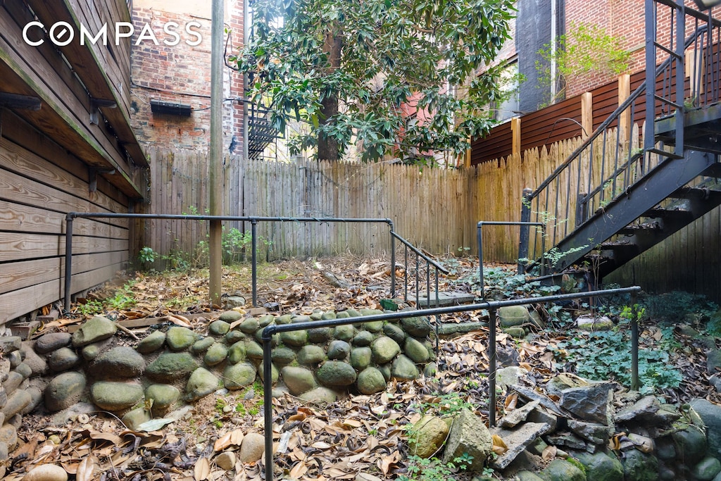 view of yard featuring stairs and fence