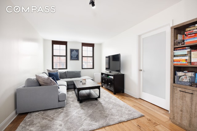 living area with light wood-style floors and baseboards
