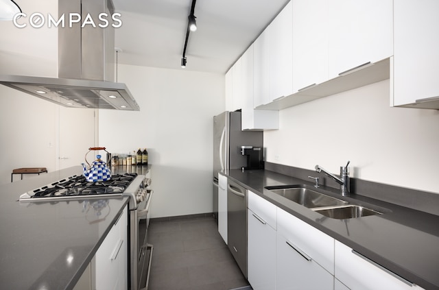 222 W 14th St Unit 3N, New York City, NY 10011 - kitchen featuring island exhaust hood, a sink, stainless steel appliances, dark countertops, and white cabinetry