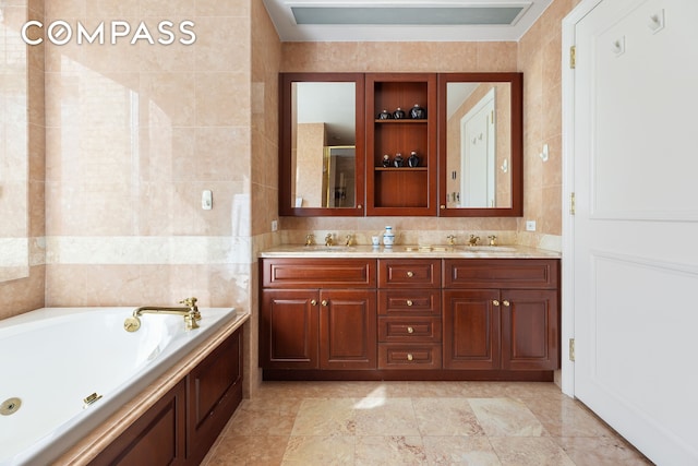 bathroom with double vanity, tile walls, a bath, a sink, and a stall shower