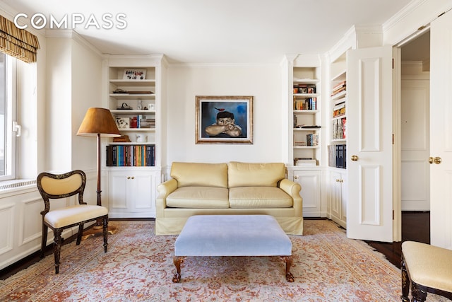 living room with crown molding, built in features, and light wood-style floors