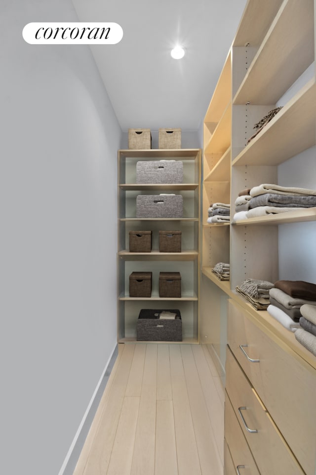 walk in closet with wood finished floors