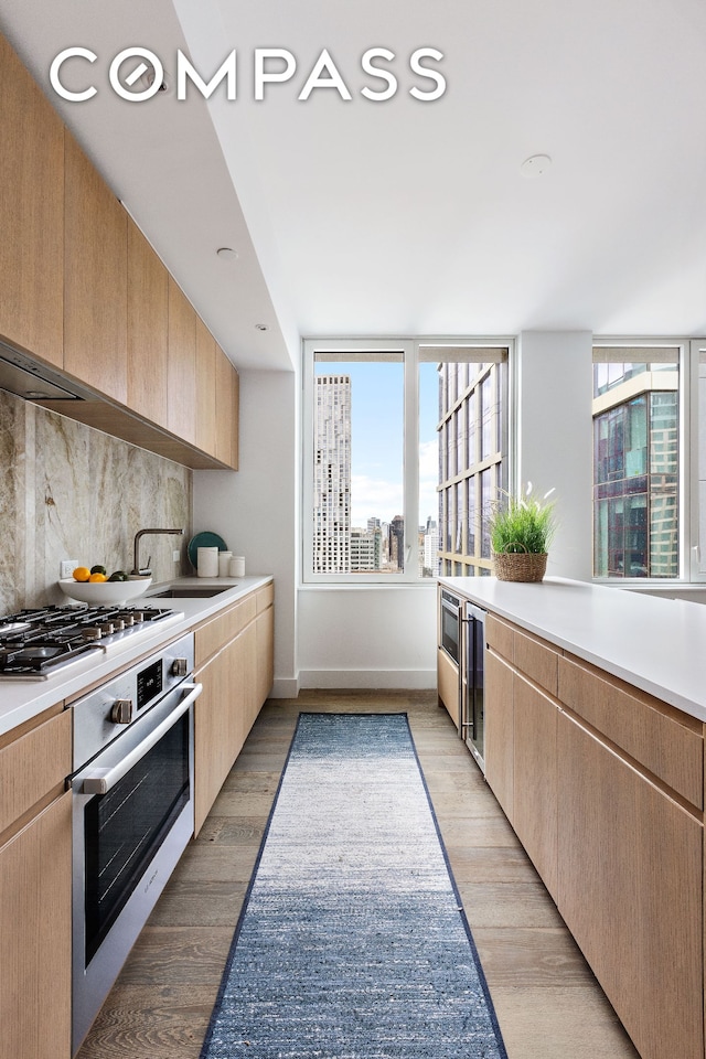 10 Nevins St Phb, Phb, New York City, NY 11217 - kitchen with stainless steel appliances, light brown cabinetry, light countertops, wine cooler, and light wood-style floors