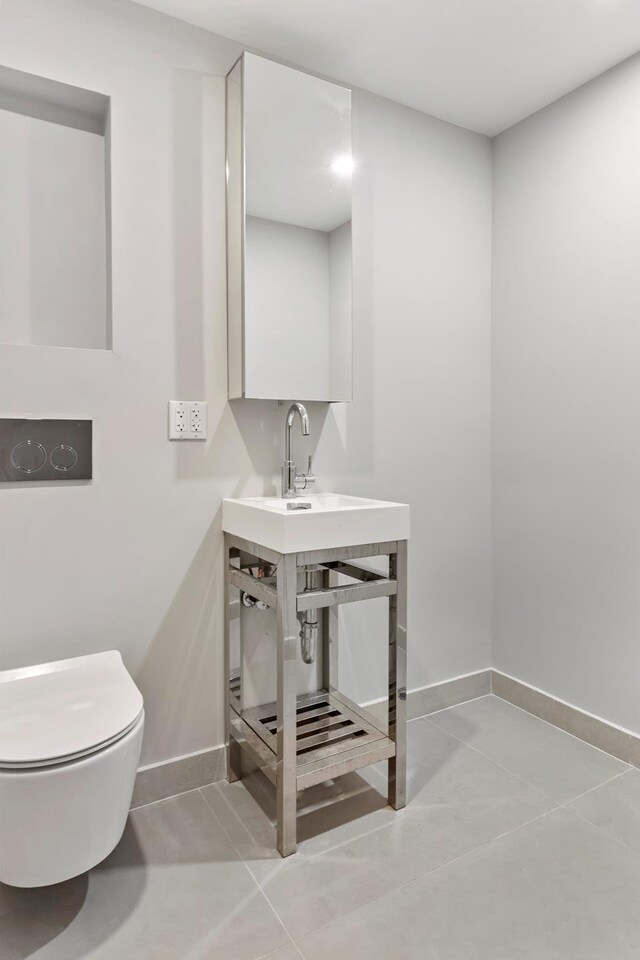 156 Devoe St Unit 1F, New York City, NY 11211 - bathroom with baseboards, toilet, tile patterned flooring, and a sink