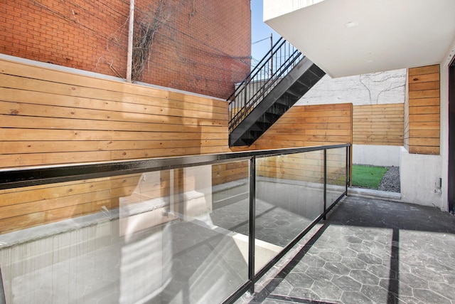 staircase featuring a towering ceiling and wooden walls