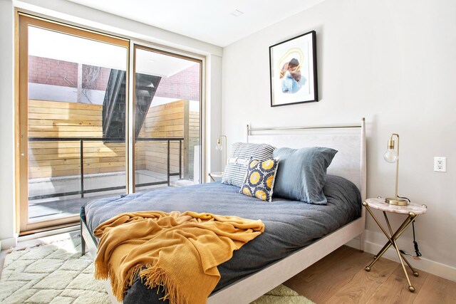 156 Devoe St Unit 1F, New York City, NY 11211 - bedroom with access to exterior, wood finished floors, and baseboards