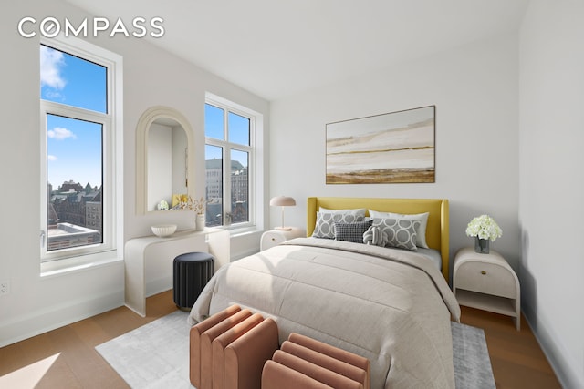bedroom with baseboards and wood finished floors