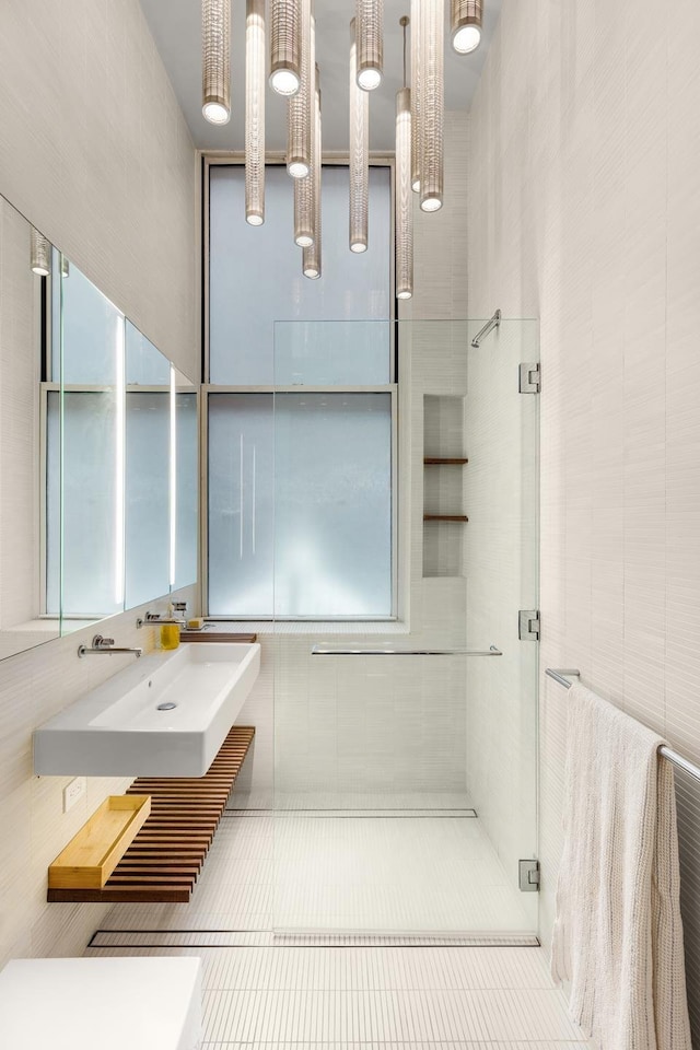 235 E 49th St Unit 1H, New York City, NY 10017 - full bathroom with tile walls, a stall shower, and tile patterned floors