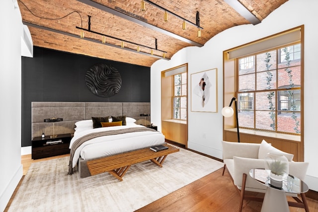 36 Bleecker St Unit 4A, New York City, NY 10012 - bedroom featuring baseboards, wood finished floors, brick ceiling, multiple windows, and track lighting