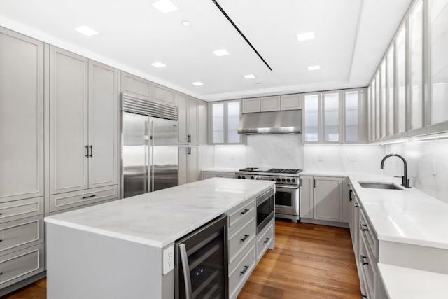 36 Bleecker St Unit 4A, New York City, NY 10012 - kitchen with built in appliances, wine cooler, under cabinet range hood, a sink, and gray cabinets