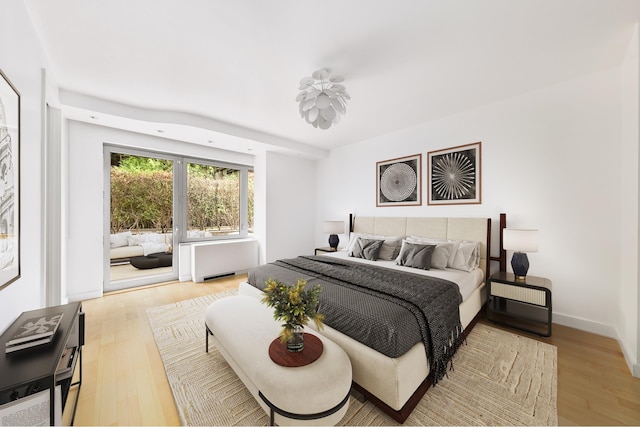 bedroom with radiator heating unit and wood finished floors