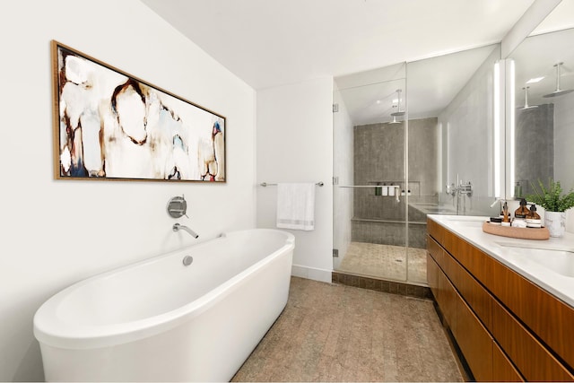 bathroom featuring a shower stall, double vanity, and a freestanding bath