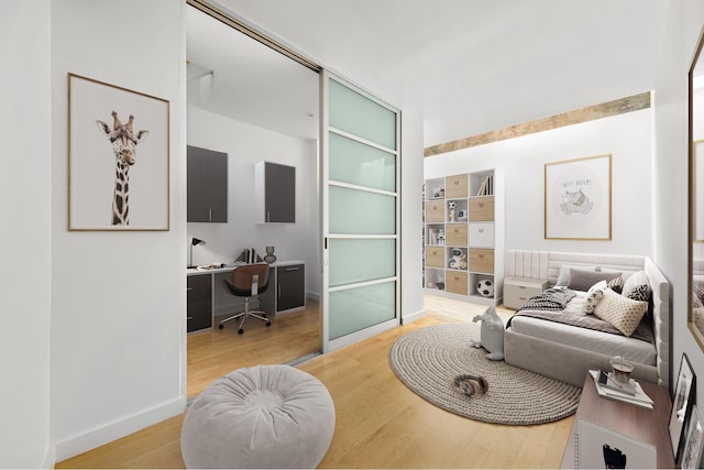 living room with a desk, wood finished floors, and baseboards