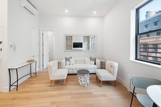 living area featuring a wall mounted AC, wood finished floors, recessed lighting, and baseboards