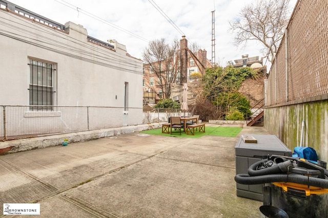 view of patio / terrace with outdoor dining area, fence, and stairway