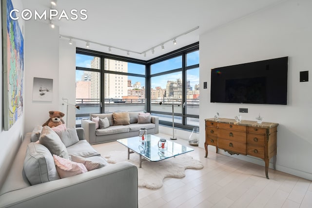 450 E 83rd St Unit 6B, New York City, NY 10028 - living area with rail lighting, floor to ceiling windows, and baseboards