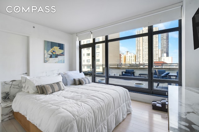bedroom with a city view and light wood-style floors