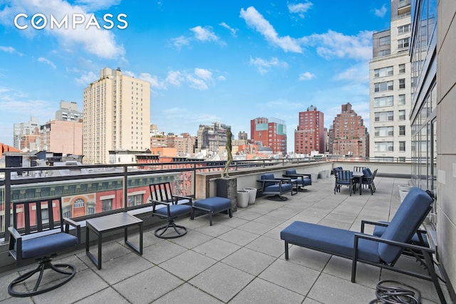 view of patio with a view of skyline and a balcony
