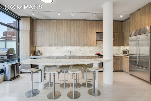 450 E 83rd St Unit 6B, New York City, NY 10028 - kitchen with appliances with stainless steel finishes, modern cabinets, track lighting, and a breakfast bar area