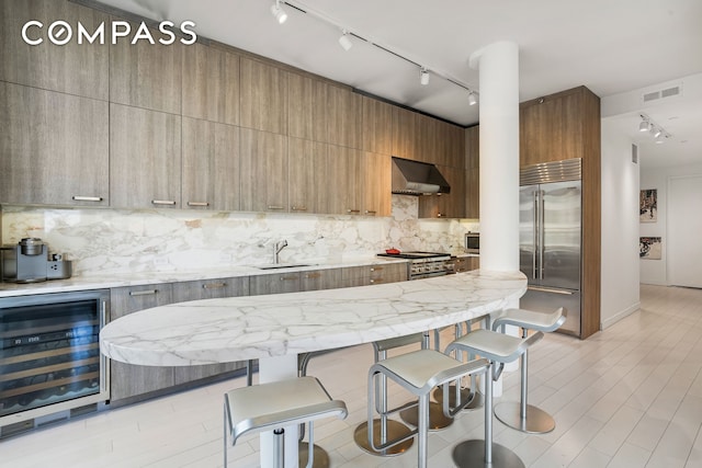 450 E 83rd St Unit 6B, New York City, NY 10028 - kitchen with premium appliances, wine cooler, track lighting, and exhaust hood