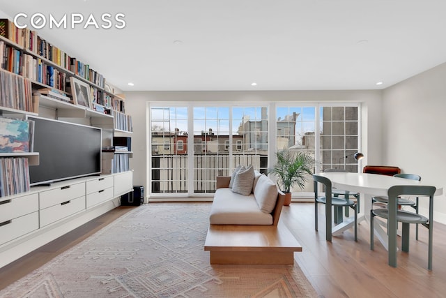 living room with wood finished floors, recessed lighting, and baseboards