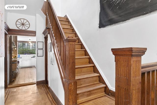 stairway with visible vents, a towering ceiling, and baseboards