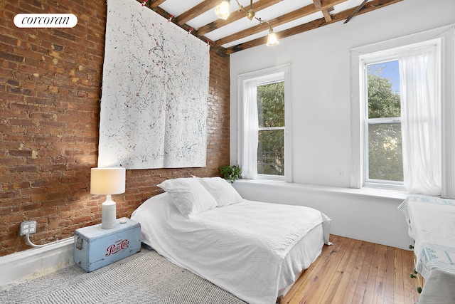 639 74th St, New York City, NY 11209 - bedroom with brick wall, beamed ceiling, and hardwood / wood-style flooring